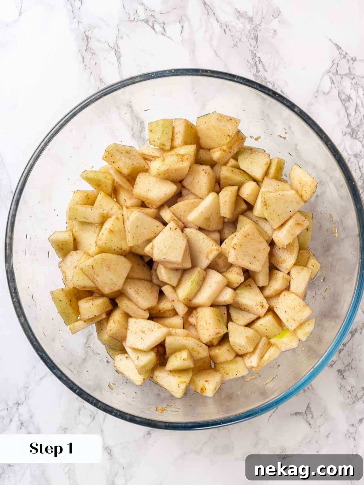 Effortless Golden Apple Crisp 5 Sliced apples mixed with spices and lemon juice in a glass bowl, ready for baking.