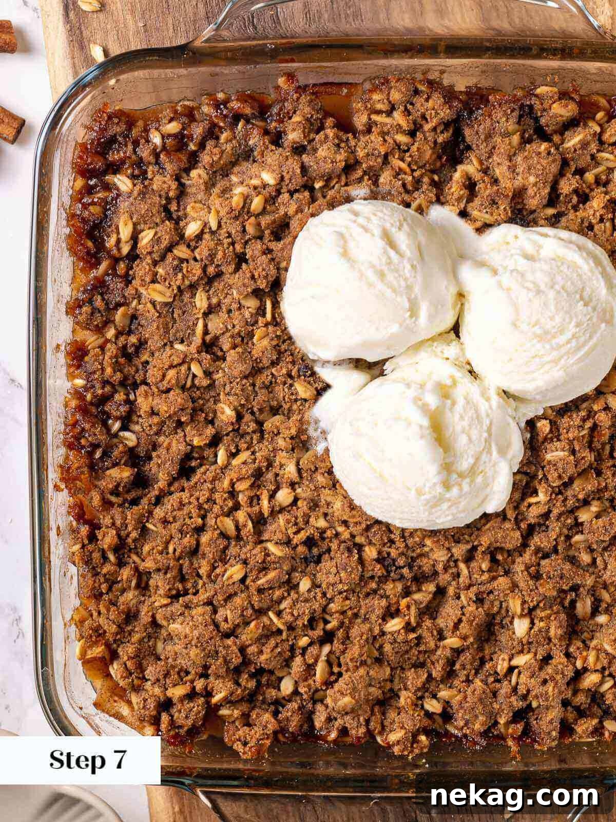 Effortless Golden Apple Crisp 9 Baked apple crisp in a baking dish, with melting ice cream on top, ready to be served.