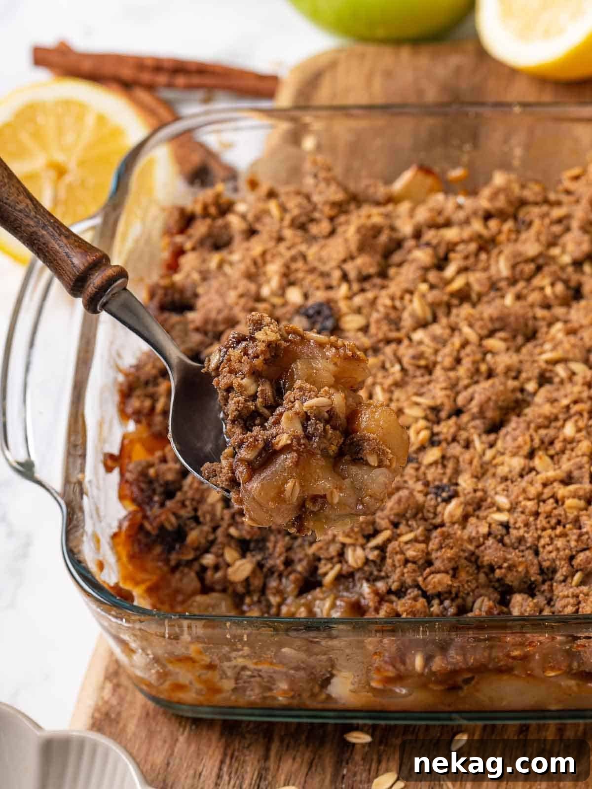 Effortless Golden Apple Crisp 10 A serving of easy apple crisp being scooped from a baking dish, showcasing its gooey filling and crispy topping.