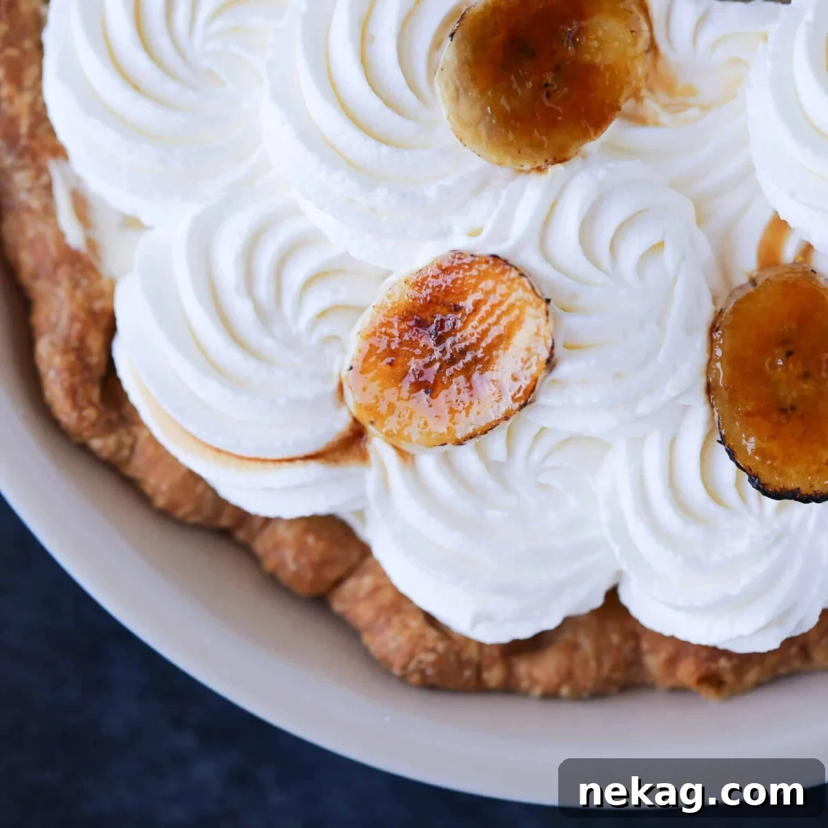 Mastering Blind Baking for a Perfect Pie Crust 12 Close-up of a Banana Cream Pie with beautiful whipped cream swirls and a golden crust.