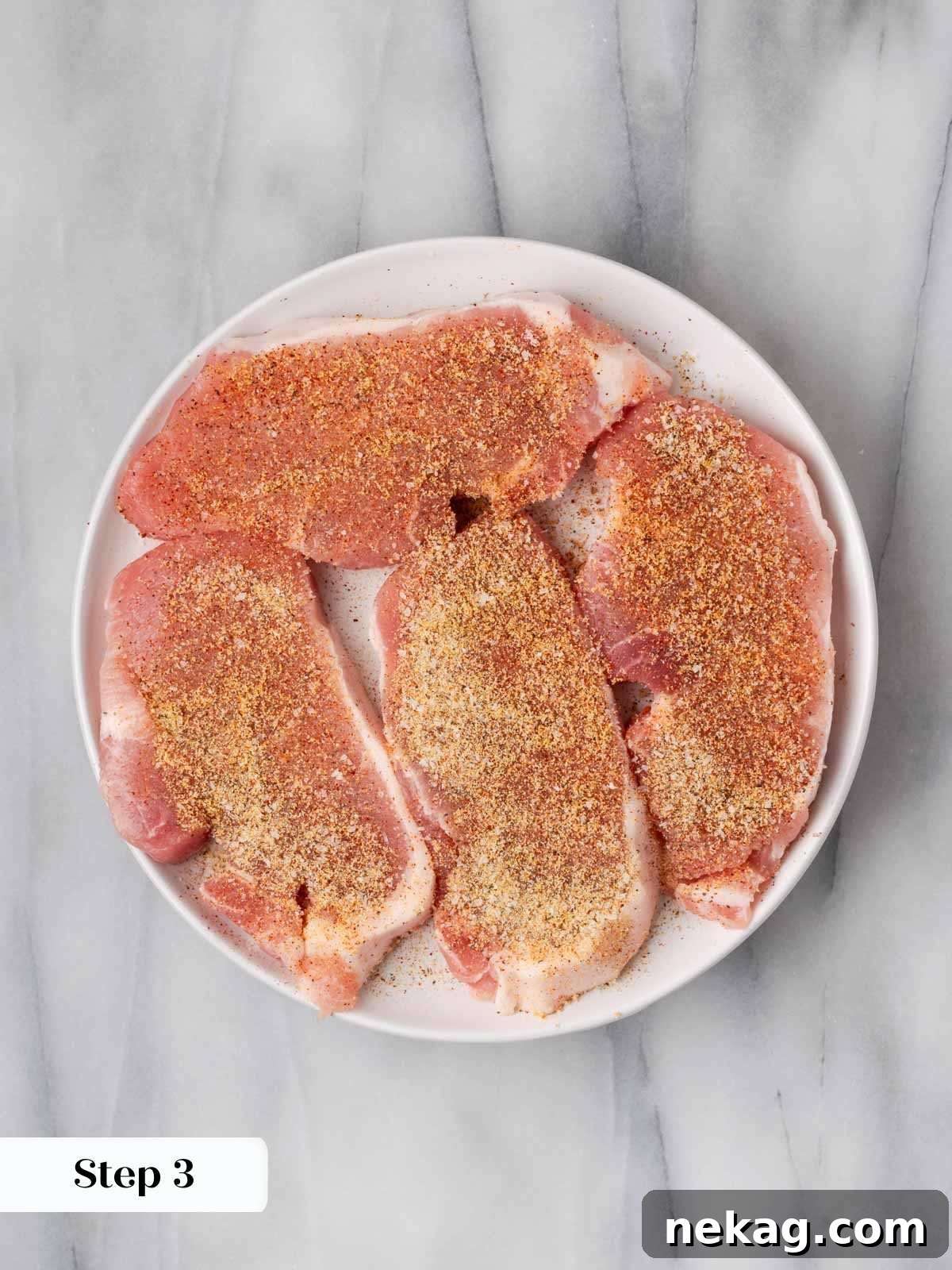 Creamy Mushroom Smothered Pork Chops 6 Seasoned pork chops neatly arranged on a plate, ready for breading.