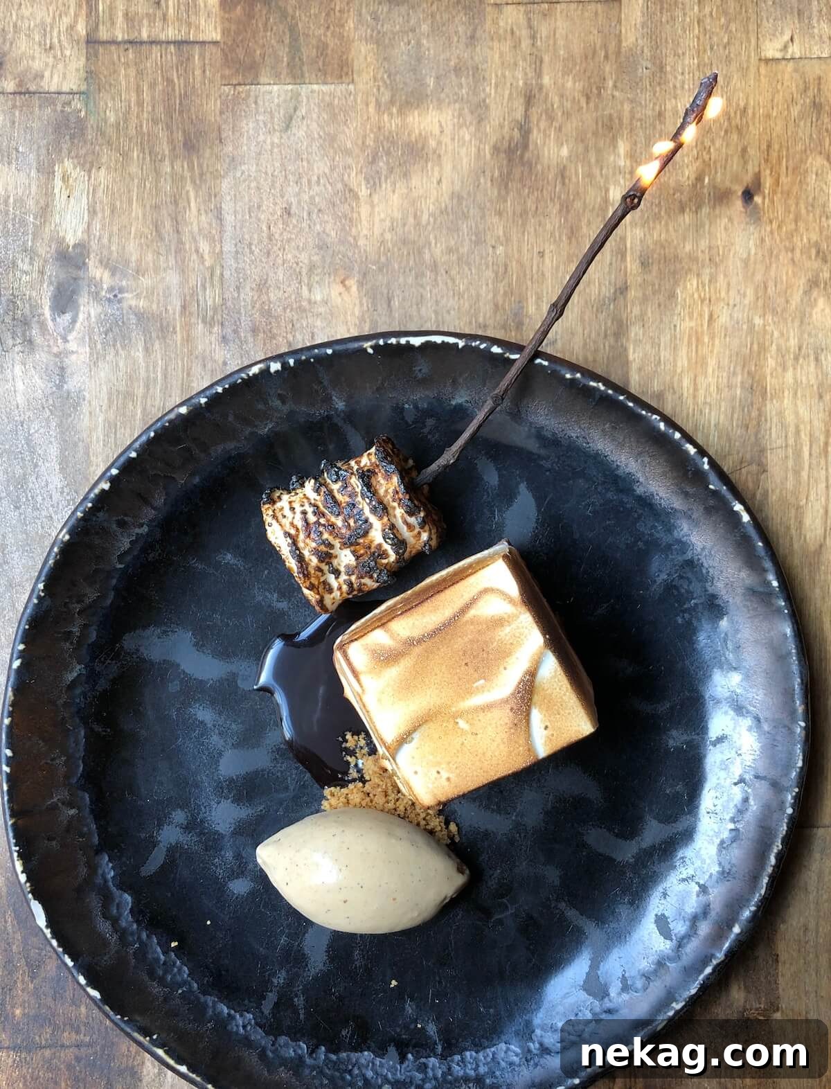 Heavenly Marshmallow Frosting 3 Plated s'mores dessert on a sophisticated black plate, featuring toasted meringue.