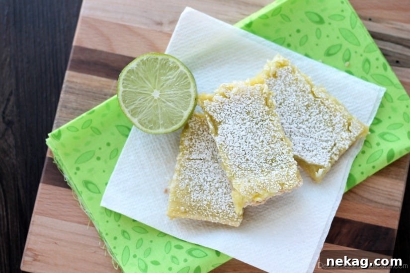Zesty Coconut-Lime Dream Bars 5 A serving of Coconut Key Lime Bars, dusted with powdered sugar and garnished with lime slices