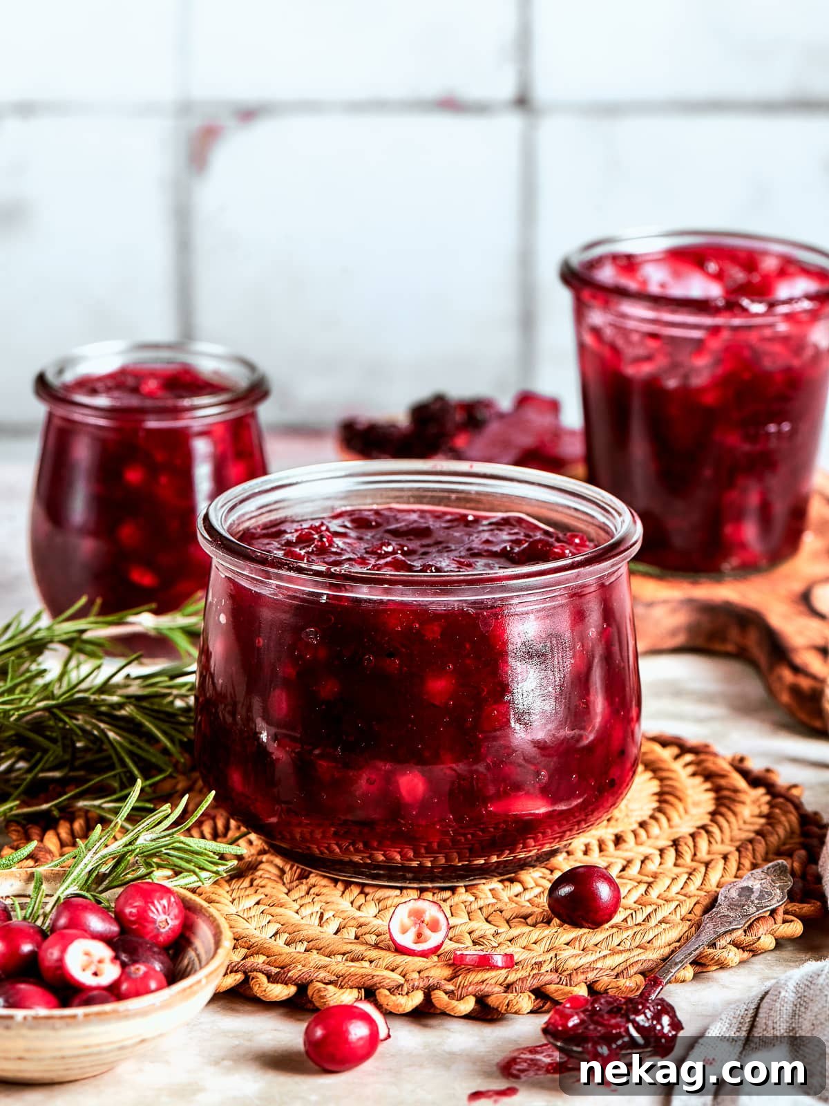 Ruby Red Holiday Delight 10 Three glass jars of freshly made cranberry sauce cooling on the counter, ready to store in the fridge for future enjoyment throughout the year.