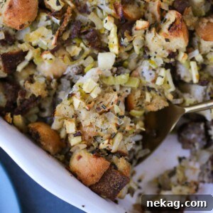 Apple Sage Sausage Stuffing being served with a spoon.