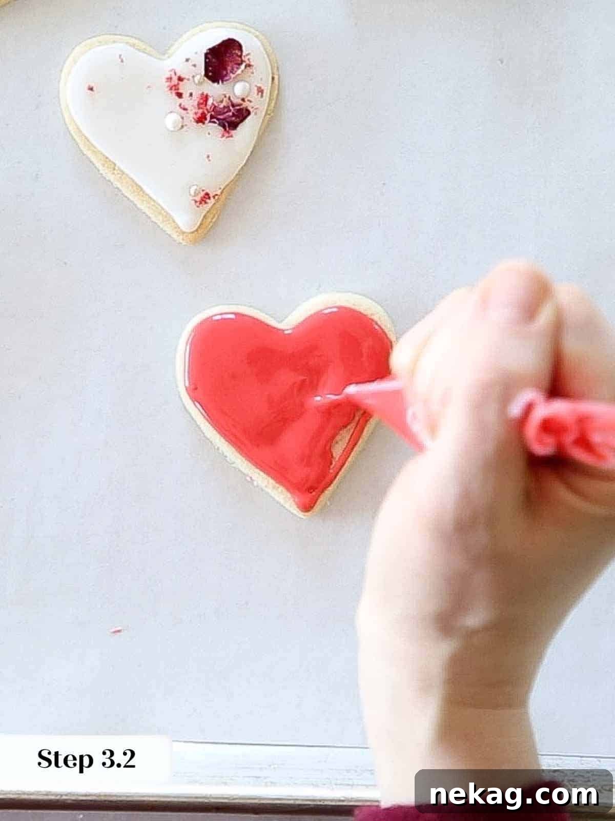 Sweetheart's Delight Cookies 13 The process of flooding a heart-shaped sugar cookie with red royal icing, spreading it evenly within the piped outline for a smooth finish.