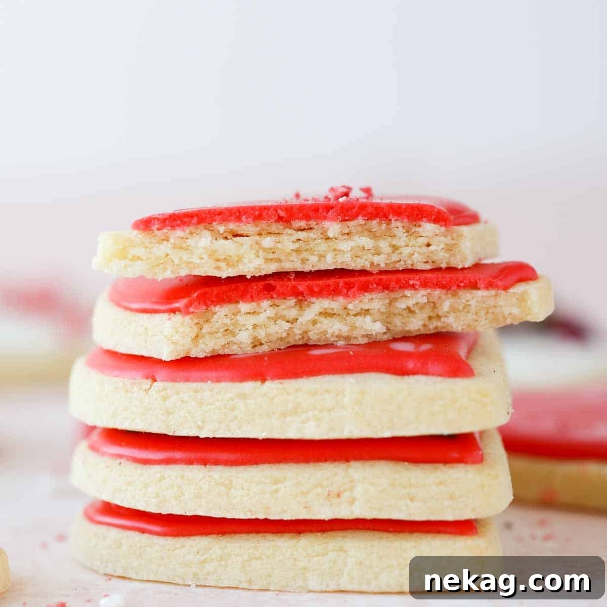 Sweetheart's Delight Cookies 4 A stack of perfectly iced sugar cookies, with one broken open to reveal its soft and tender interior, demonstrating the ideal texture of these Valentine's Day treats.