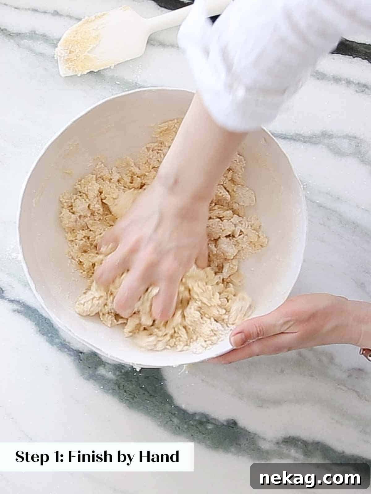 Sweetheart's Delight Cookies 7 Hands demonstrating the process of mixing sugar cookie dough by hand in a large bowl, ensuring all ingredients are well combined.