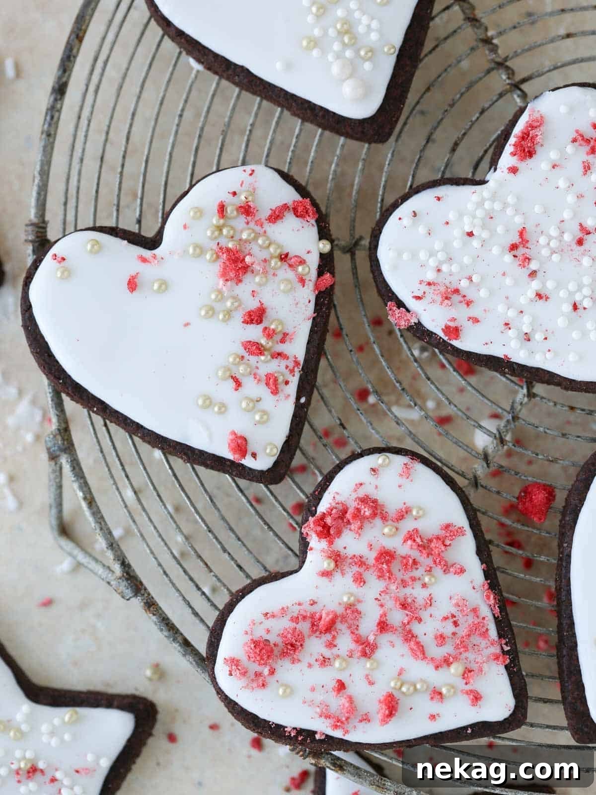 Rich Chocolate Sugar Cookies 2 A collection of beautifully frosted heart-shaped chocolate sugar cookies on a cooling rack, showcasing various decorating styles.