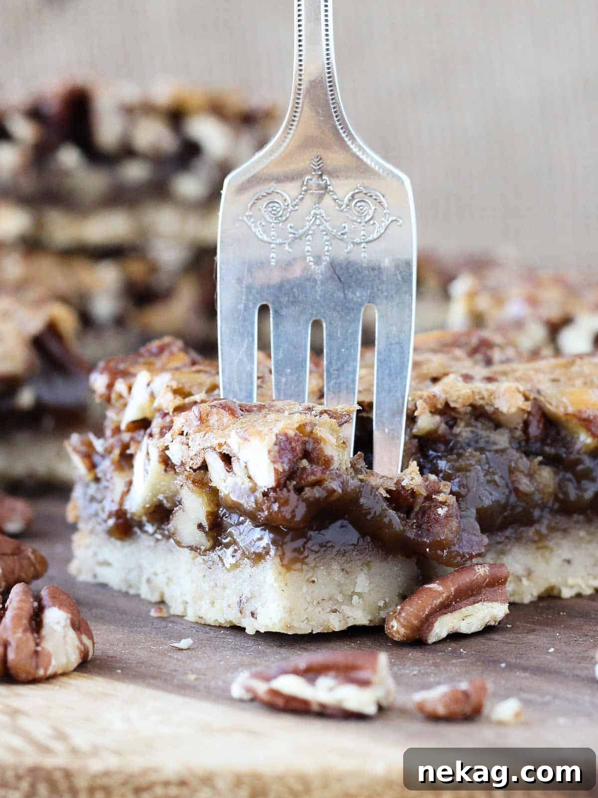 Decadent Pecan Pie Squares 4 pecan pie bar with a fork taking a bite, showing the gooey filling and crisp crust.