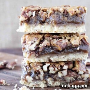 pecan pie bars stacked on wooden surface with brown background.