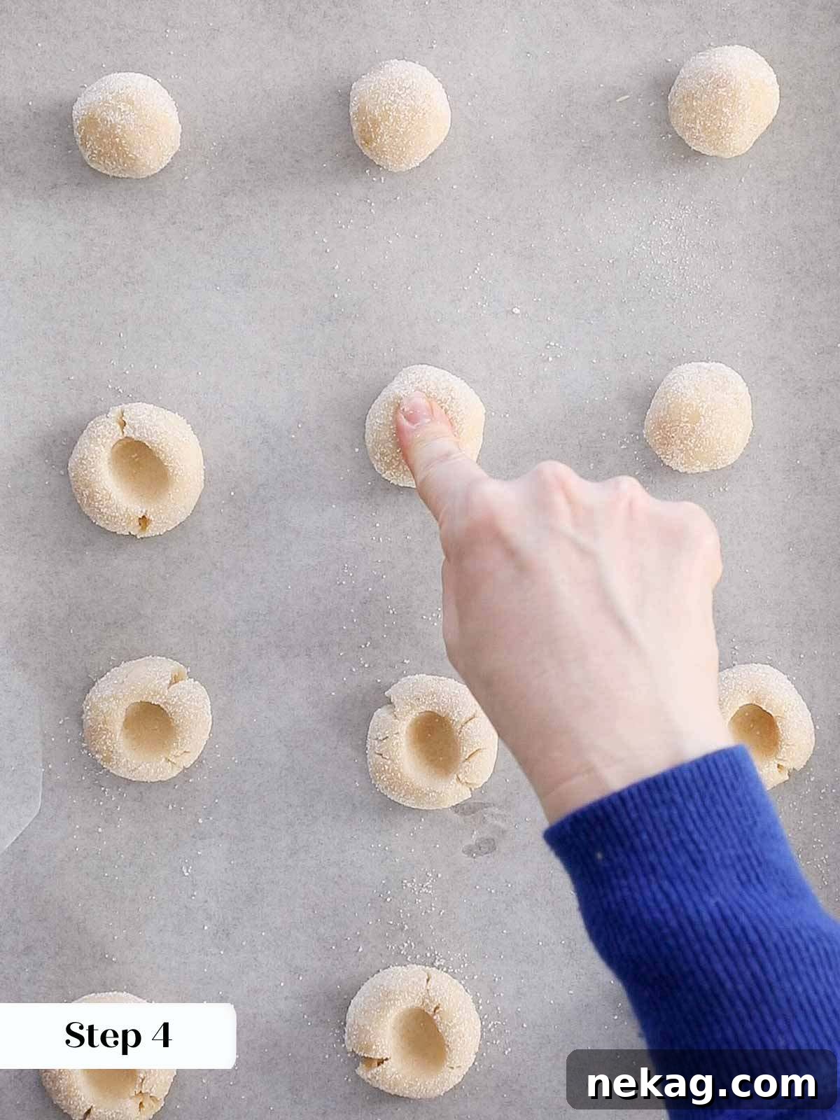 Preserve-Kissed Shortbreads 8 A finger gently pressing an indentation into the cookie dough.
