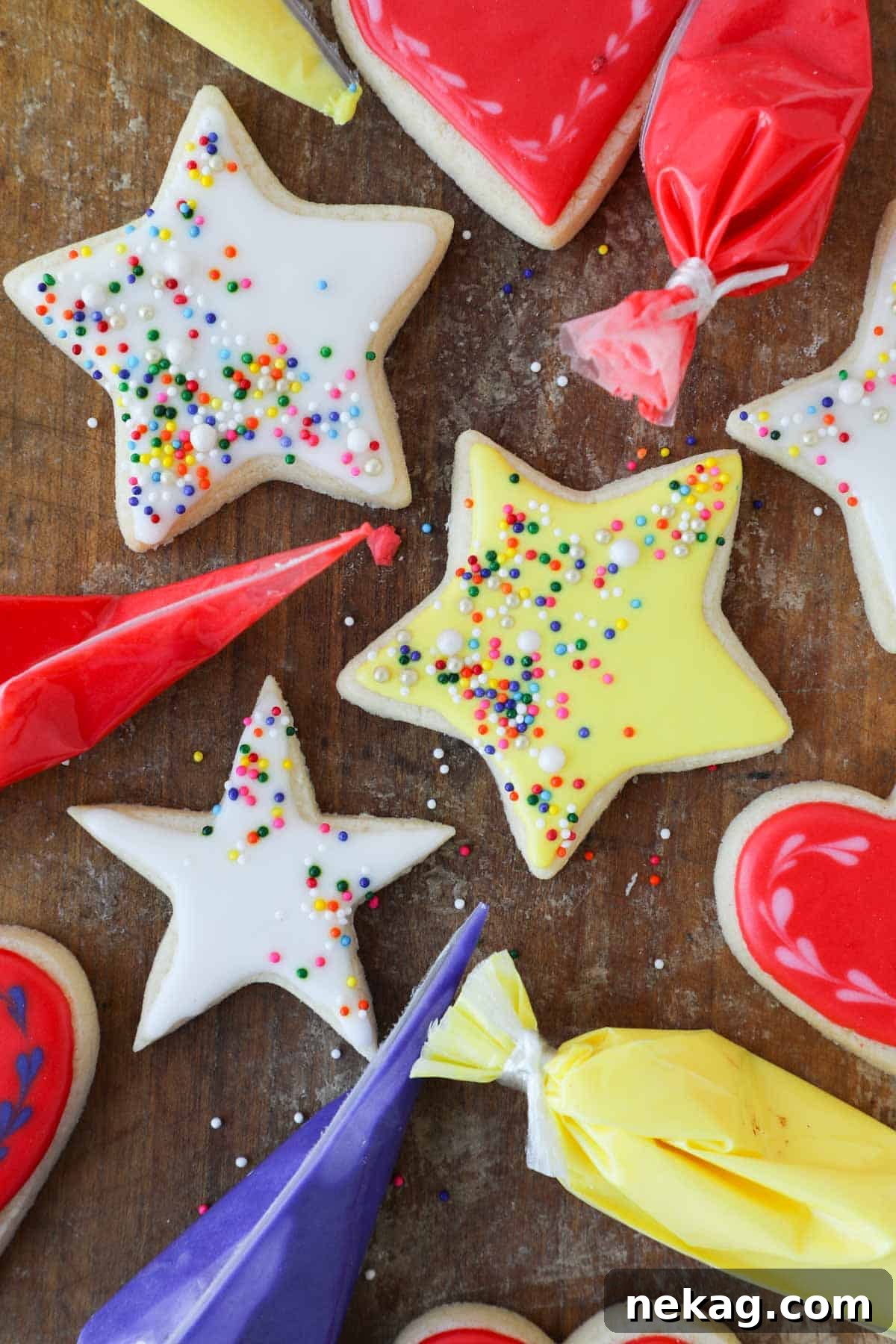 Flawless Royal Icing Made Easy with Meringue Powder 2 iced stars in yellow and white on wooden surface.