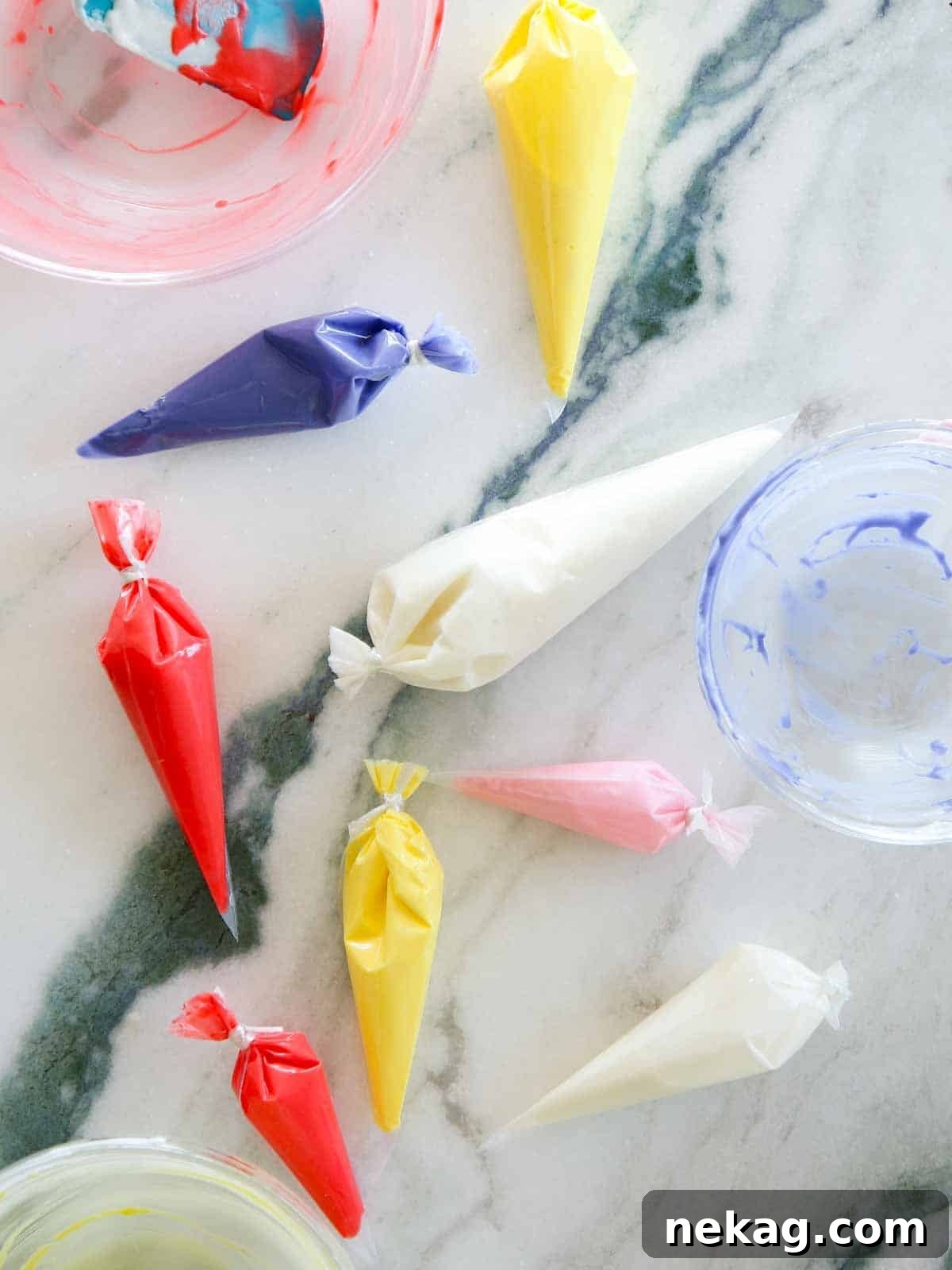 Flawless Royal Icing Made Easy with Meringue Powder 12 royal icing in bags on marble.