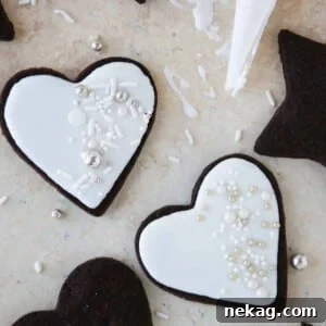 Two perfectly iced sugar cookies showcasing the smooth, shiny finish of the easy cookie icing.