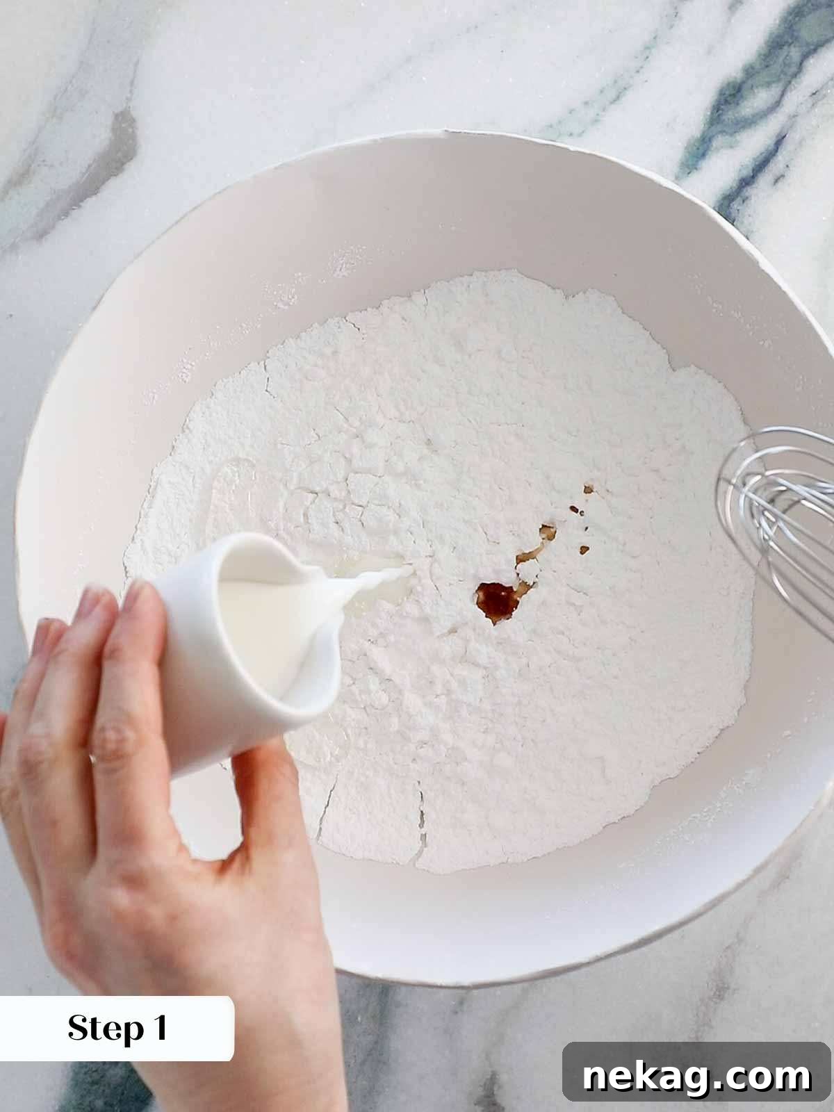 Adding all dry and wet ingredients into a white mixing bowl for easy cookie icing preparation.