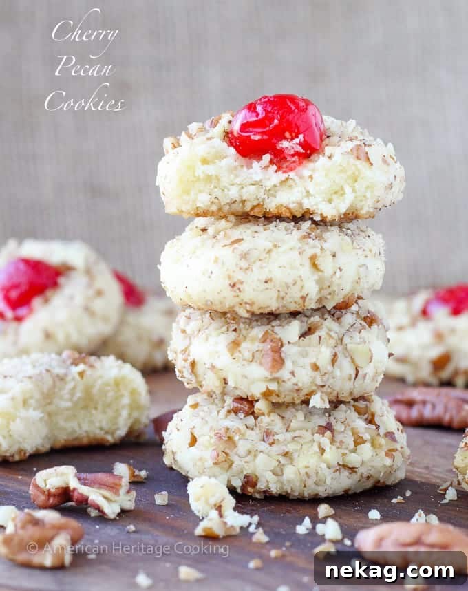 Close-up of a single cherry pecan cookie on a baking sheet.
