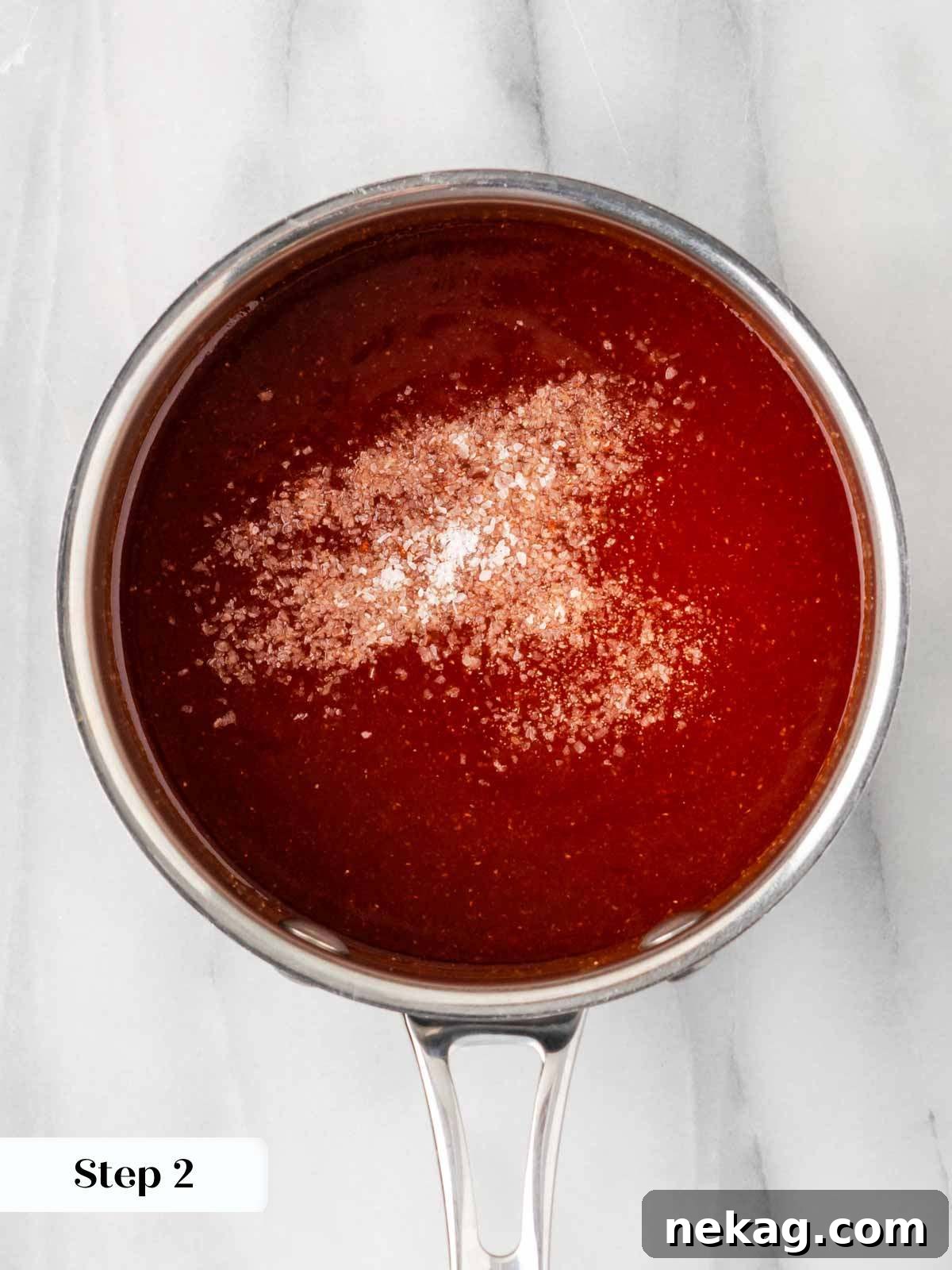 Adding salt to the simmering homemade BBQ sauce to taste.