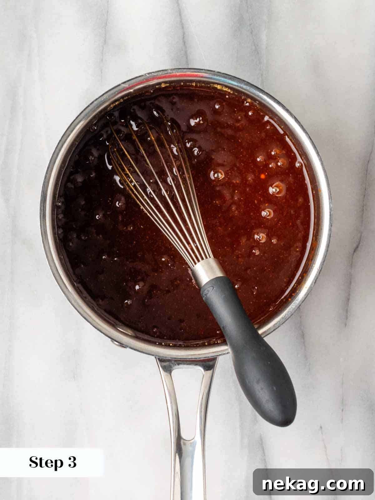 Homemade BBQ sauce boiling gently in a pot on the stove.