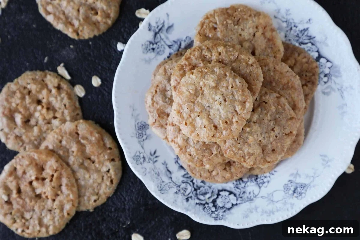 A stack of golden oat lace cookies on a rustic wooden tablescape, ready to be enjoyed or gifted.