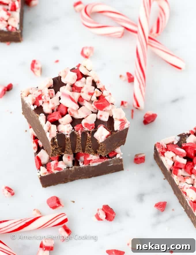 Effortless Rich Dark Chocolate Peppermint Fudge 3 Rich, chocolatey, and smooth Dark Chocolate Peppermint Fudge squares, perfect for holiday gatherings and gifting.