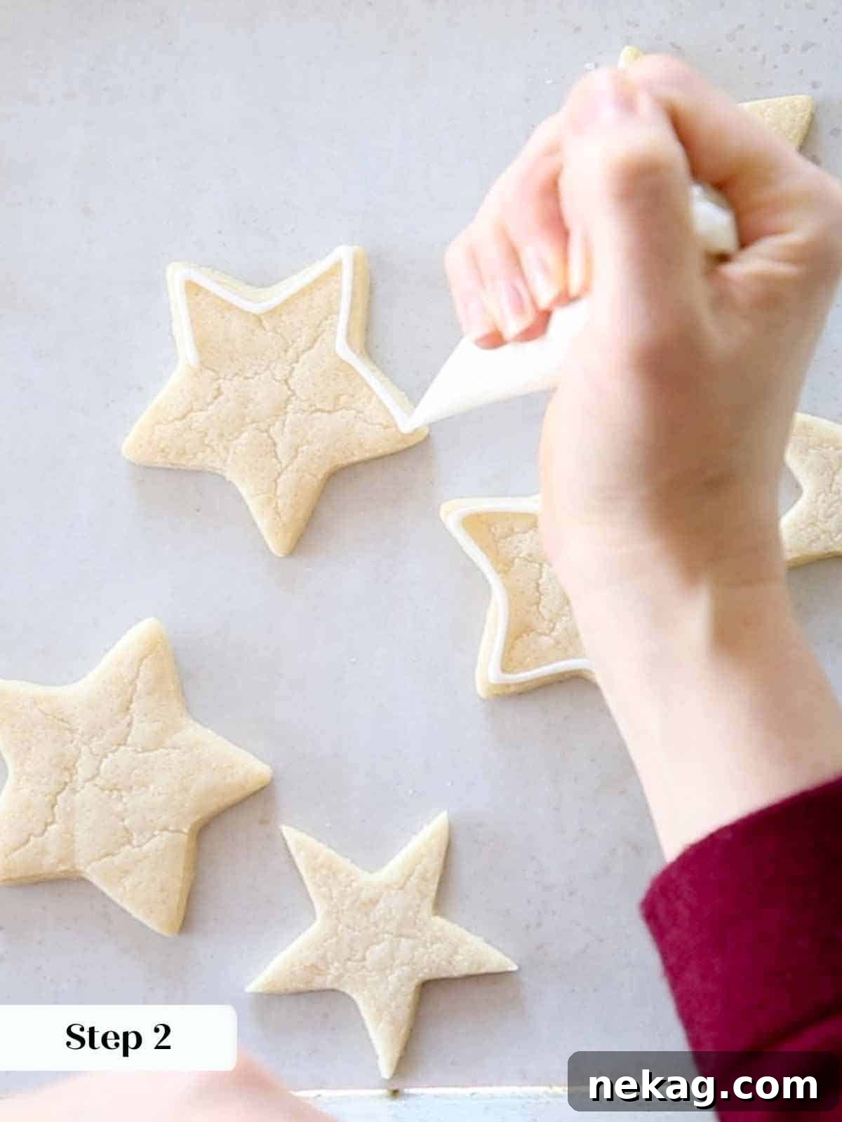 outlining white royal icing on sugar cookie stars.