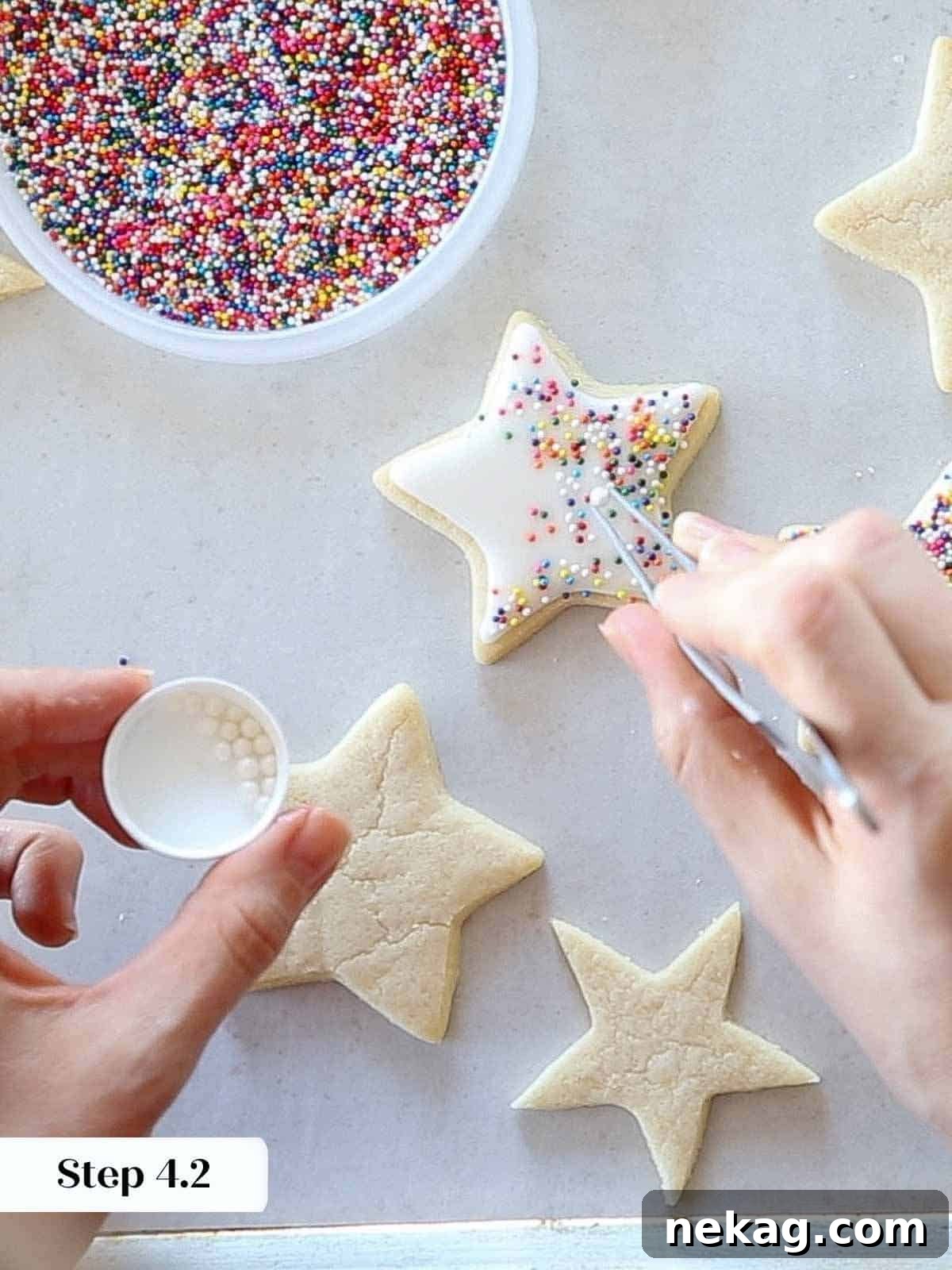 adding rainbow jimmies and sugar pearls with tweezers.