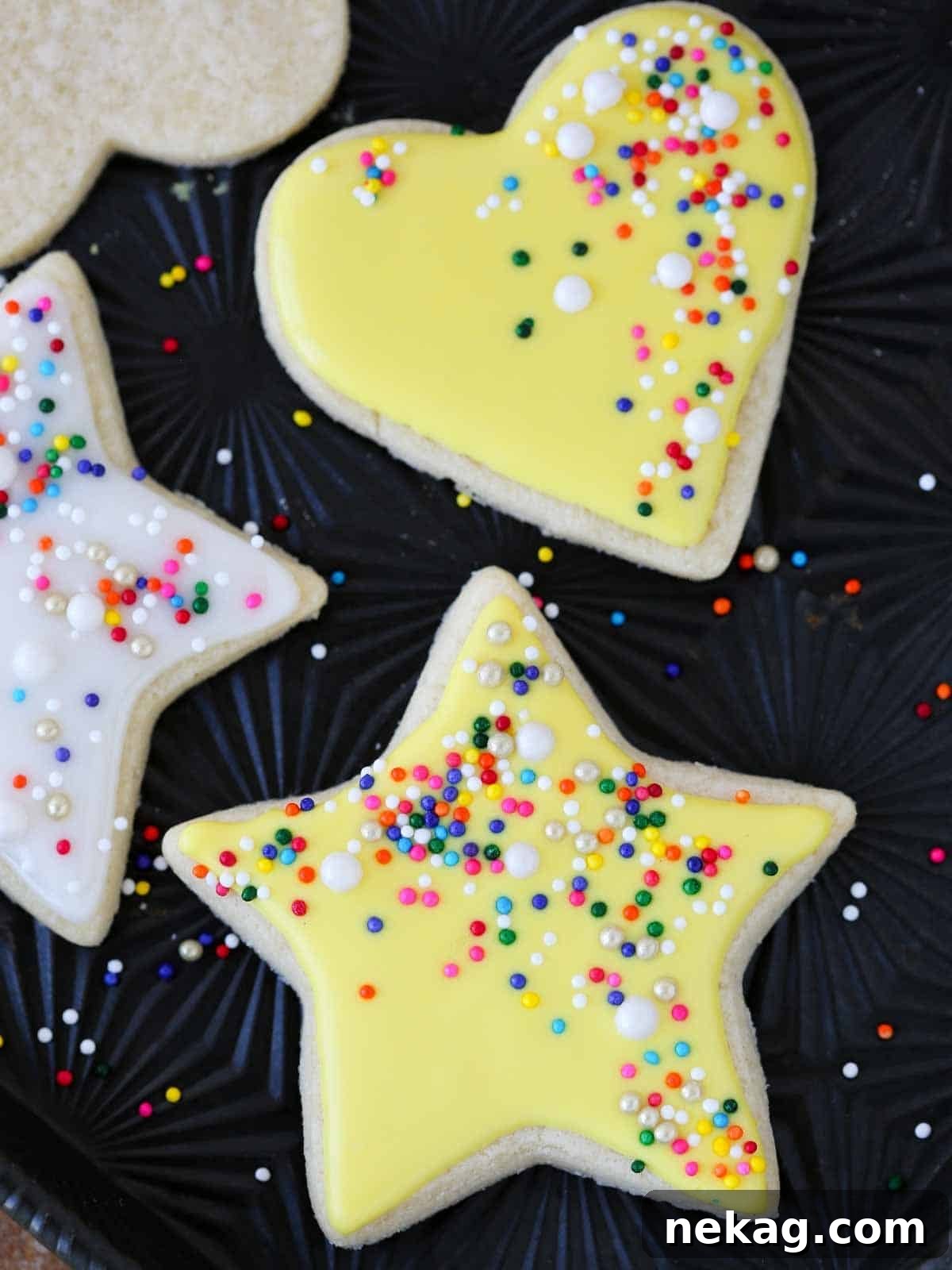 yellow star and heart cookies on black tray.
