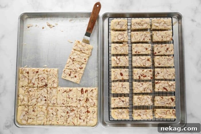 Transferring almond bars to a wire rack inside of a sheet pan.