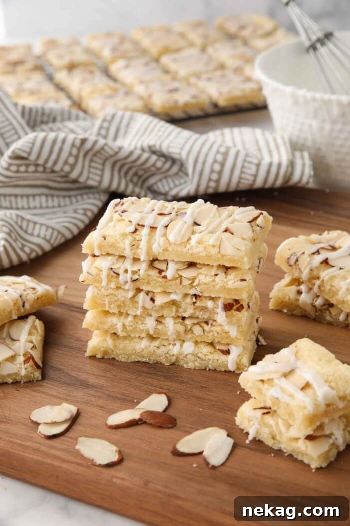 Almond Bars stacked on top of each other on top of a cutting board.