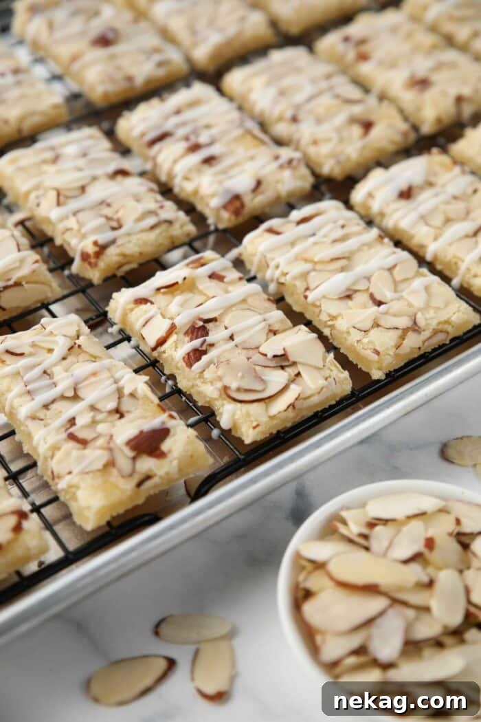 Glazed almond bars on a wire rack inside of a sheet pan.