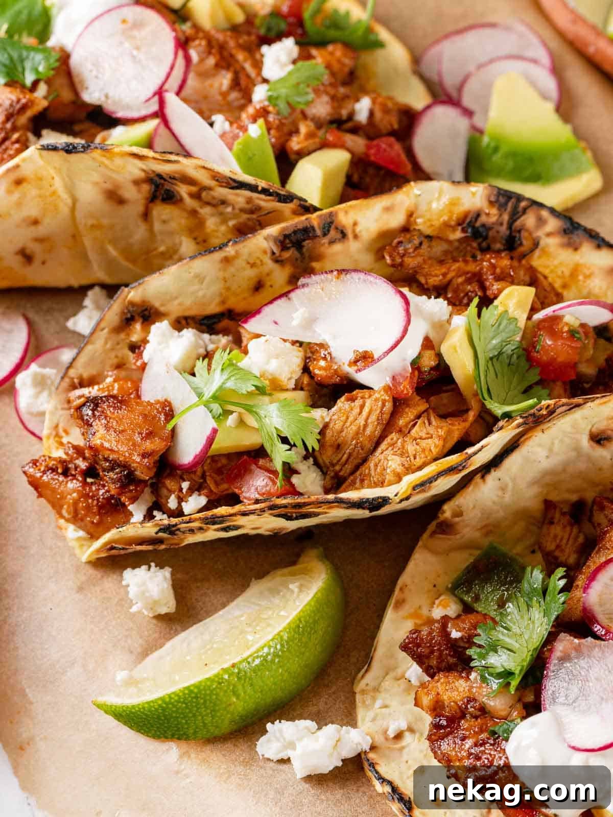 Zesty Chicken Taco Fiesta 2 Delicious chicken tacos garnished with a fresh lime wedge, ready to be enjoyed.