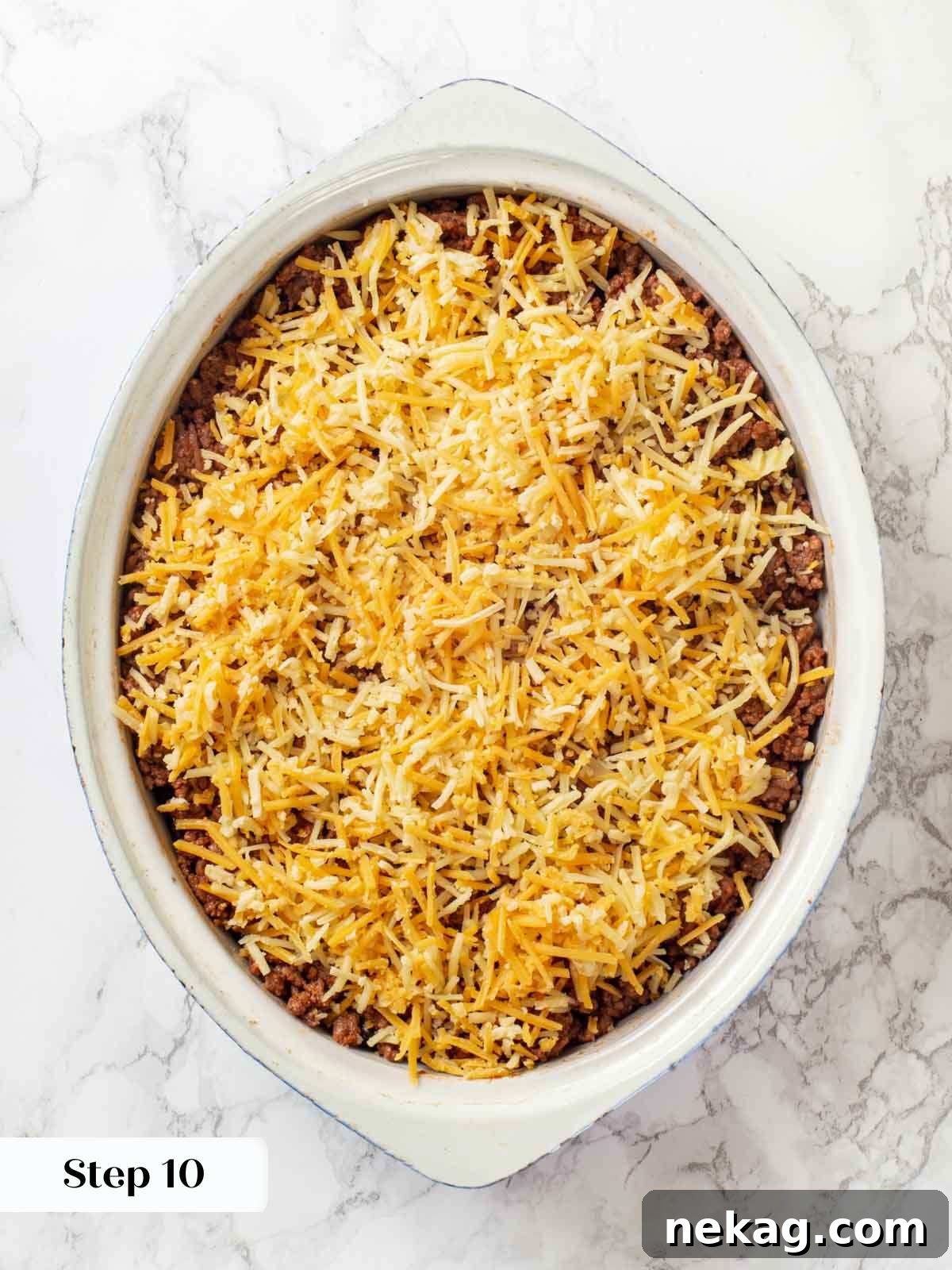 A fully layered and unbaked taco casserole, showcasing all the ingredients before cooking.