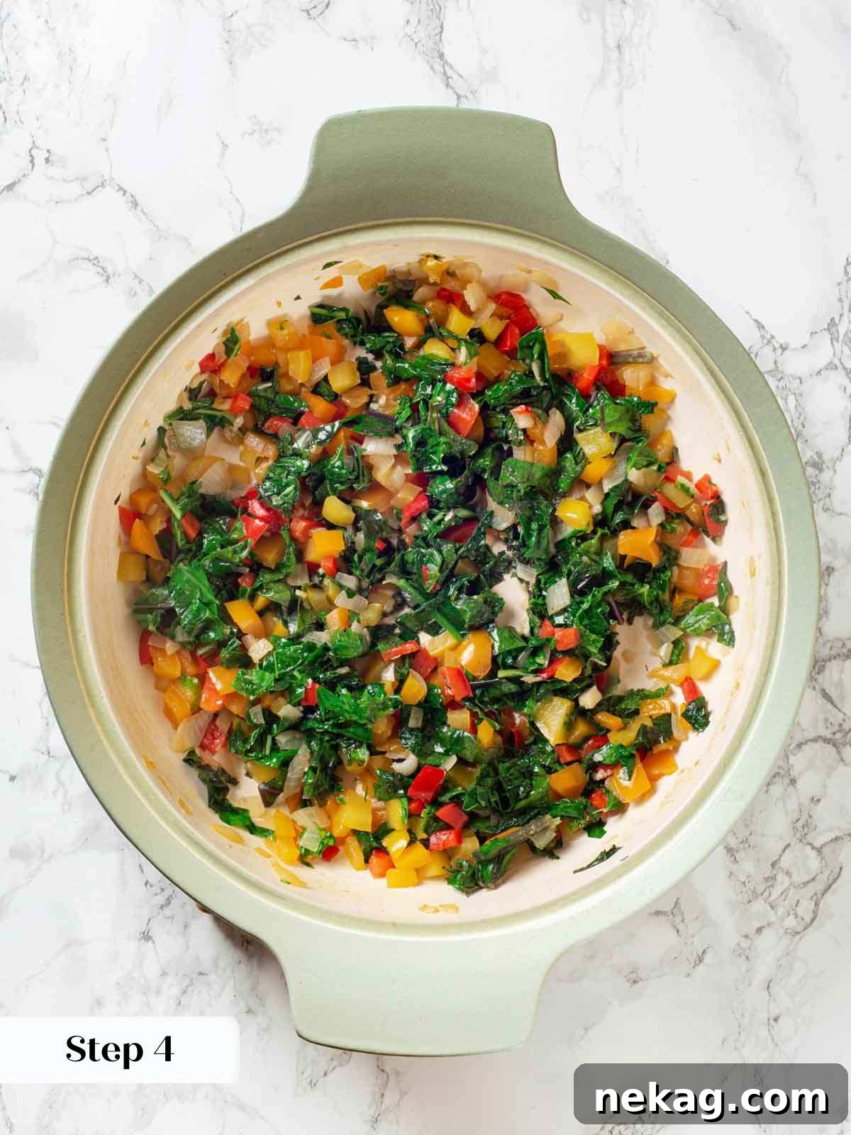 Cooked vegetables, including kale, softening in a pan for the taco casserole layers.