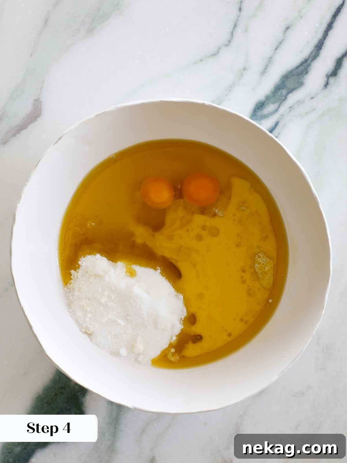 Sun-Kissed Lemon Olive Oil Cake 8 wet ingredients for olive oil cake in white mixing bowl.
