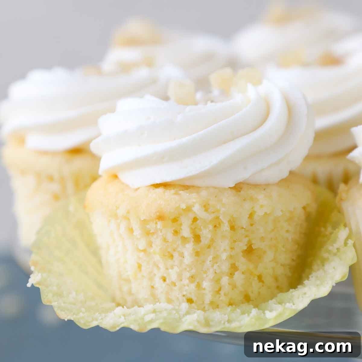 Sunshine Lemon Cupcakes 17 An unwrapped lemon cupcake in a bright yellow liner, highlighting its delicate texture.