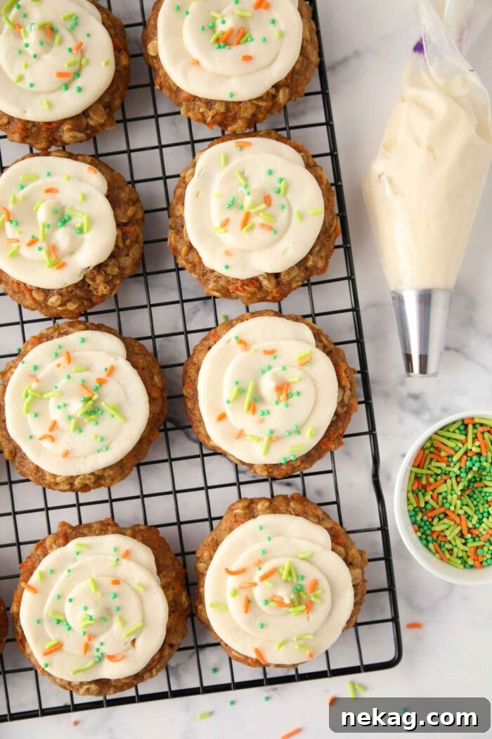 Creamy Carrot Spice Cookies 9 Carrot cake cookies topped with swirled cream cheese frosting and colorful sprinkles, ready to be served.