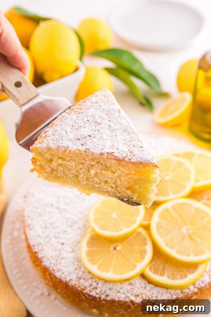 How to Bake Lemon Olive Oil Cake 3 Slice of lemon olive oil cake being lifted up with a serving spatula.