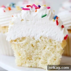 Airy ermine frosting on a cupcake split in half, showcasing its light texture.