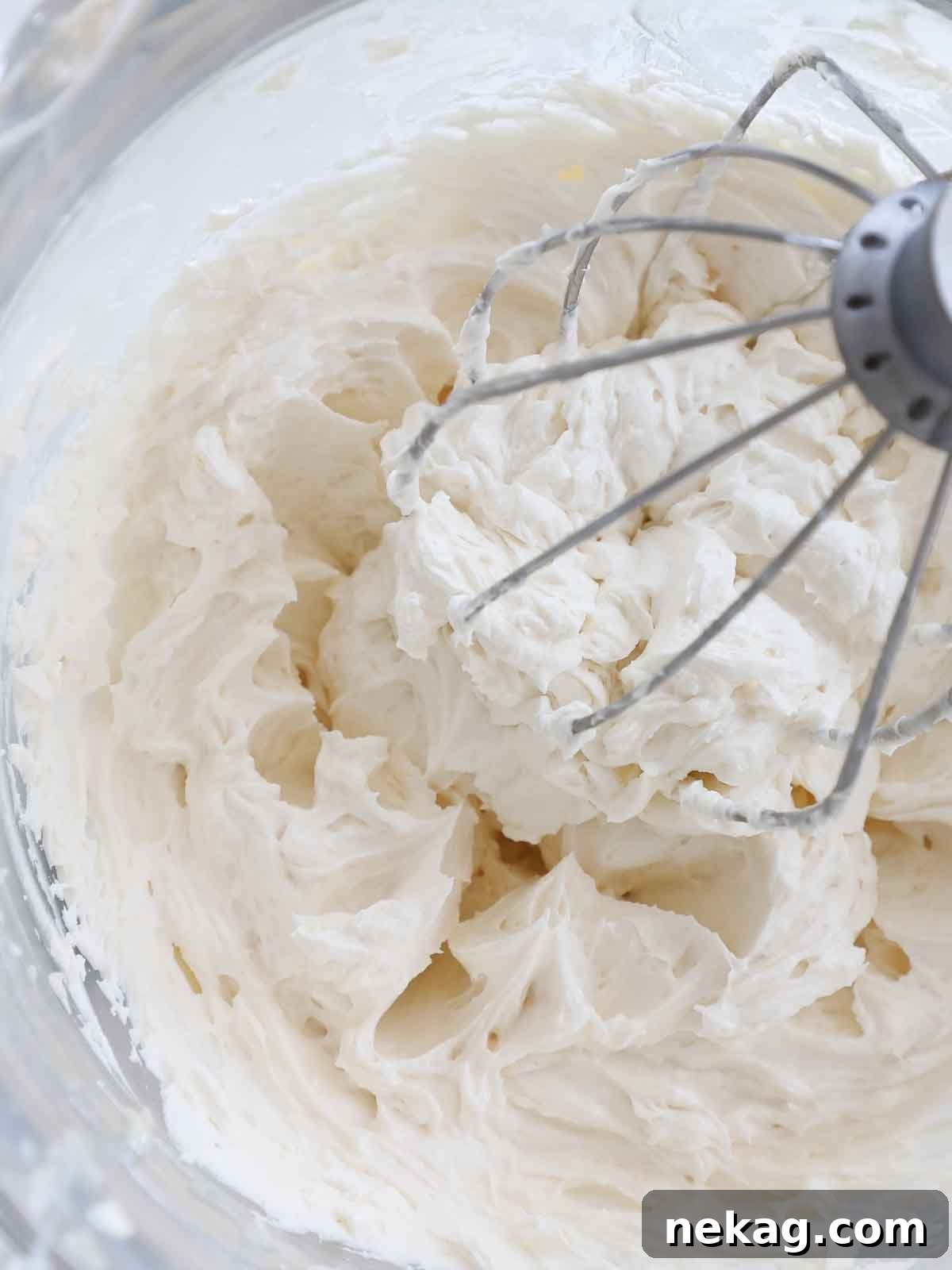 Velvety Cooked Flour Frosting 3 Close-up of light, fluffy ermine frosting in a large mixing bowl with a whisk attachment, ready for use.