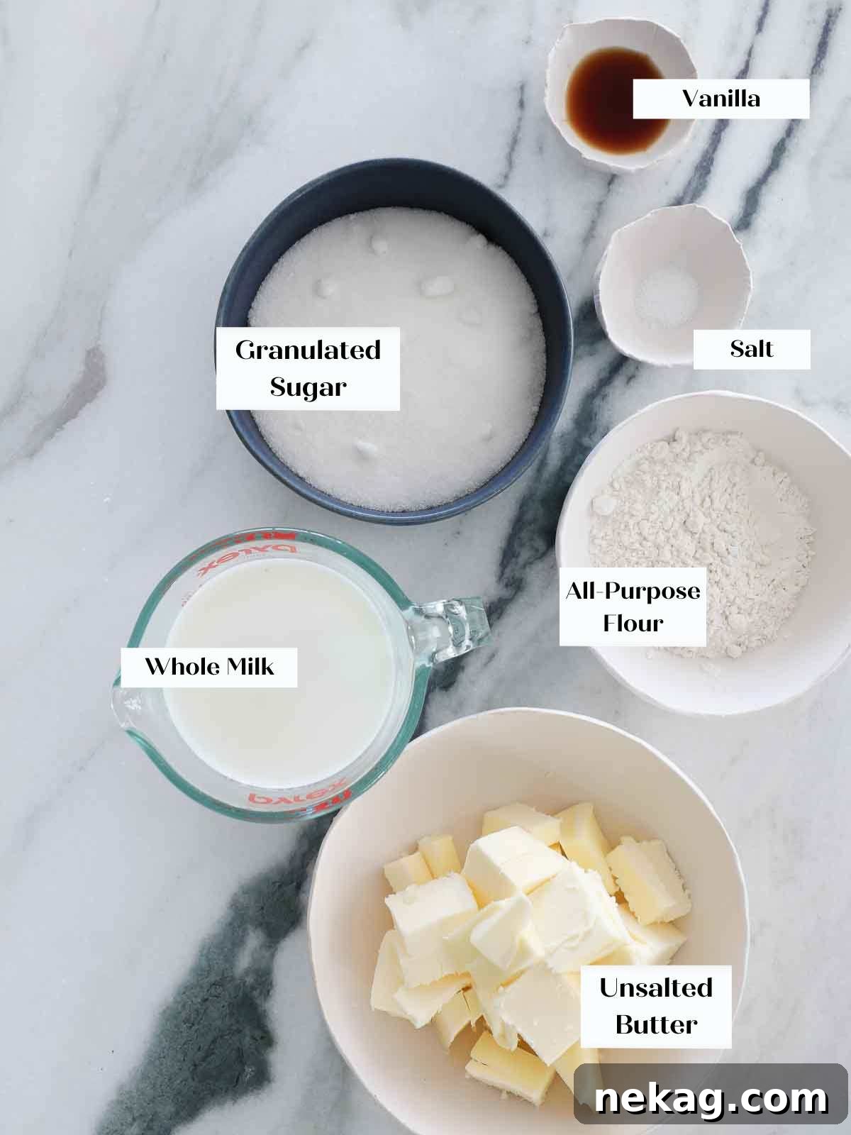 Velvety Cooked Flour Frosting 4 Ingredients for ermine frosting laid out on a marble surface, including flour, sugar, milk, butter, and vanilla extract.