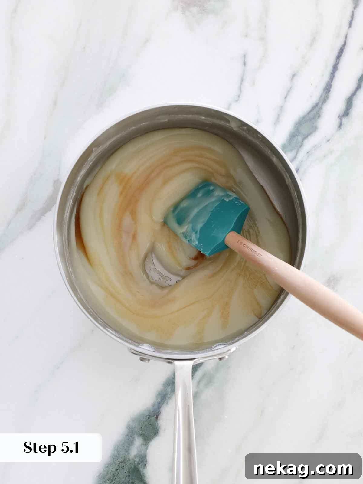 Velvety Cooked Flour Frosting 10 Vanilla extract being stirred into the hot, cooked flour base for the frosting, adding flavor.