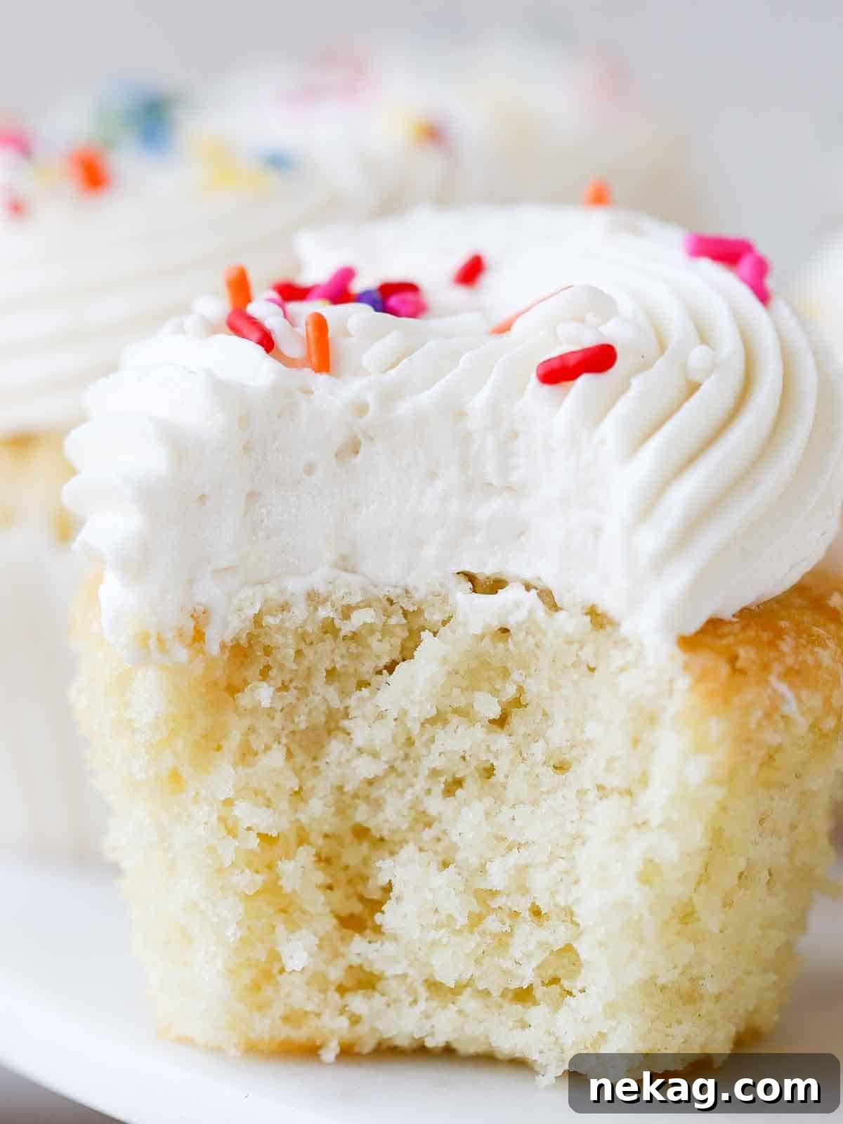 Fluffy Vanilla Delights 2 Soft, moist vanilla cupcakes with fluffy frosting, showcasing interior texture.