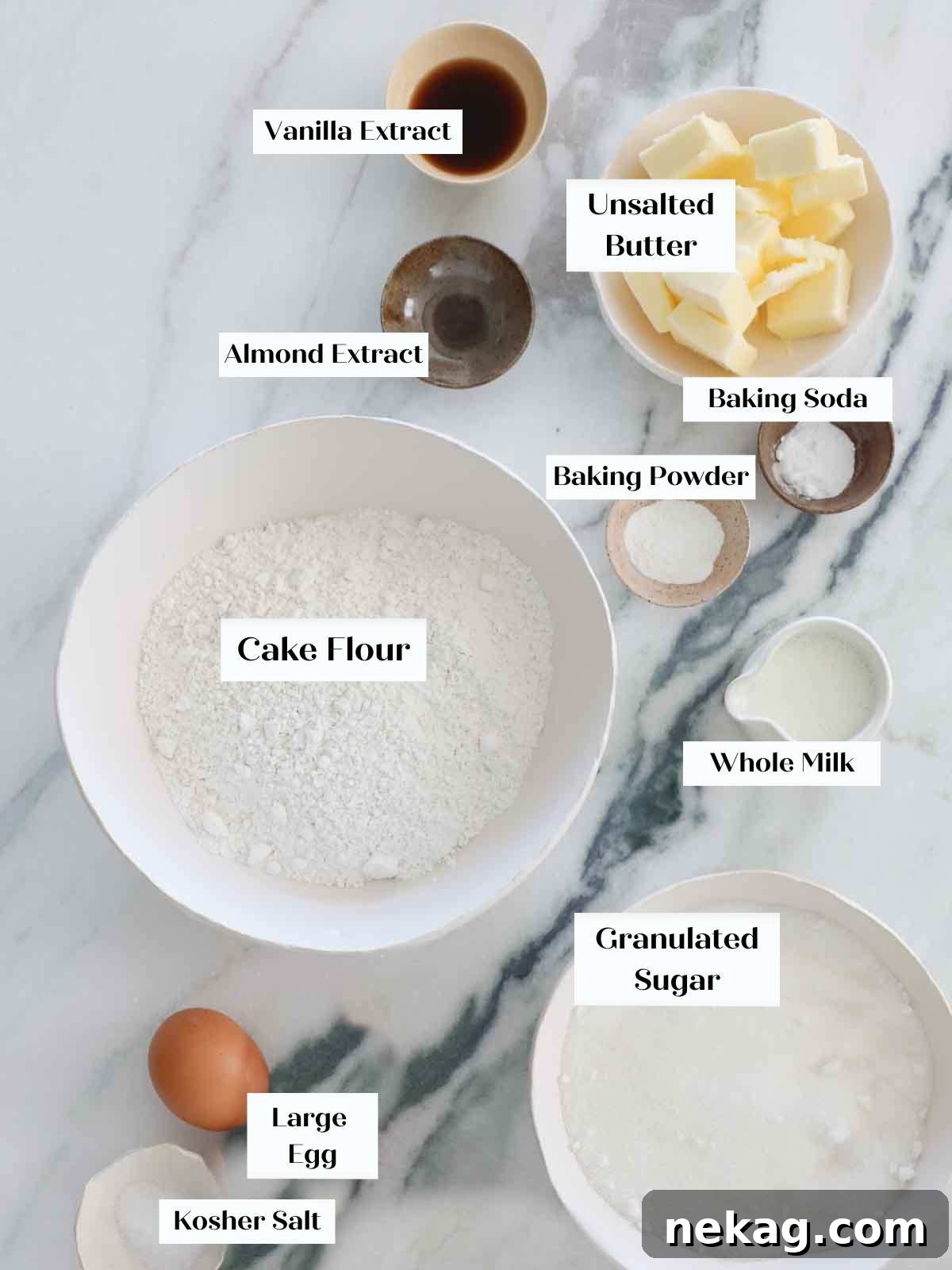 Fluffy Vanilla Delights 4 Ingredients for vanilla cupcakes laid out on a marble surface.