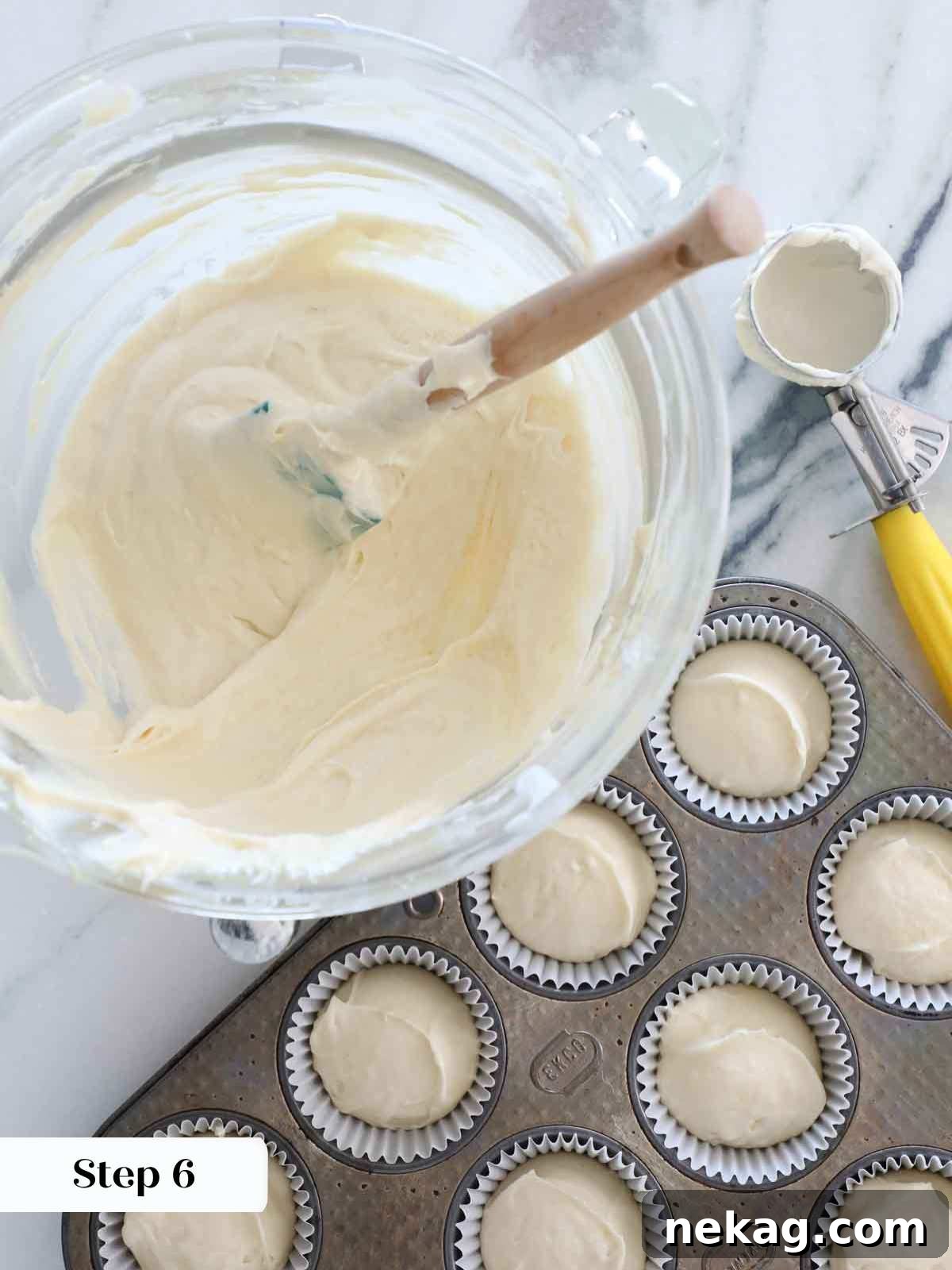 Fluffy Vanilla Delights 9 Portioning vanilla cake batter into cupcake liners.