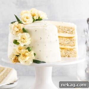 A beautiful three-layer lemon poppyseed cake, garnished with fresh lemon slices, demonstrating its inviting texture.