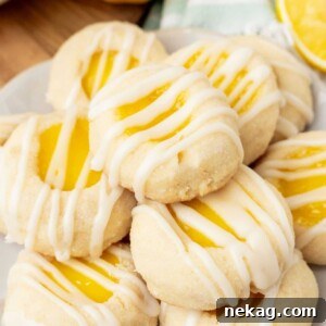 A perfectly stacked trio of Lemon Curd Thumbprint Cookies, showing off their golden edges and bright centers.
