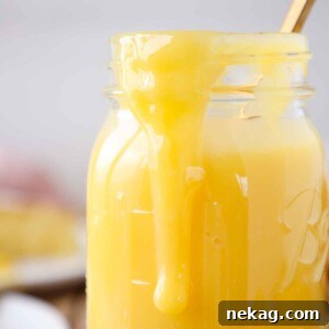 Lemon curd subtly dripping down the side of a clear mason jar, highlighting its luxurious texture.