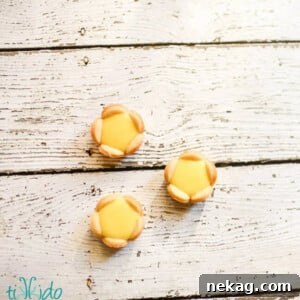 A trio of tiny, perfectly crafted lemon tartlets, each a bite-sized burst of citrus flavor.