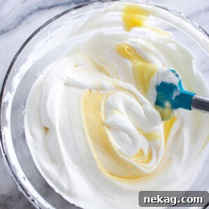 Close-up of lemon whipped cream with lemon curd being folded in, showcasing the smooth, creamy texture.